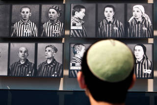 FILE PHOTO: A visitor looks at pictures of Holocaust victims at Yad Vashem's Holocaust History Museum in Jerusalem