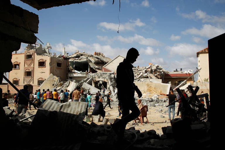 Palestinos em meio a destroços na cidade de Rafah, no sul da Faixa de Gaza