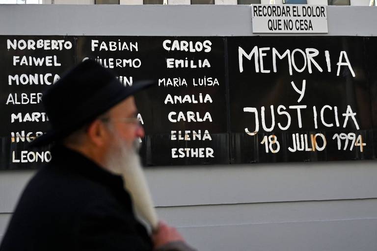 Rabino caminha perto de cartaz com nome de vítimas do ataque à Amia em 1994, em Buenos Aires