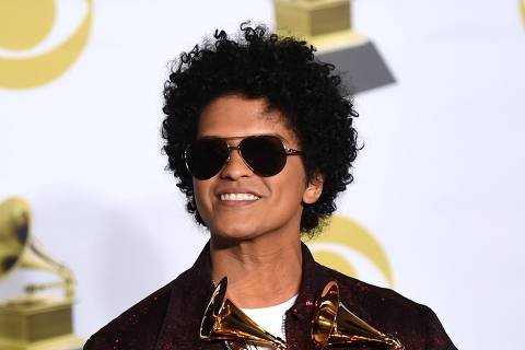 Singer Bruno Mars poses in the press room with his Grammy trophies during the 60th Annual Grammy Awards on January 28, 2018, in New York. / AFP PHOTO / Don EMMERT