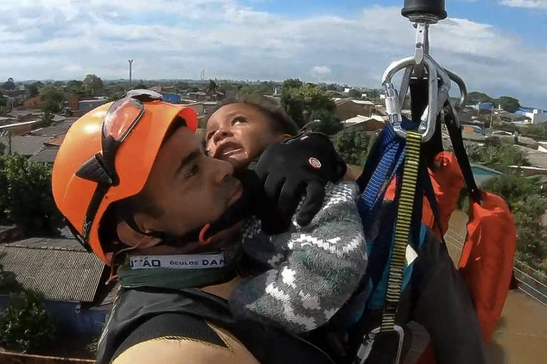 Marinheiro resgata uma criança de enchente em helicóptero no bairro de Mathias Velho, em Canoas (RS) 