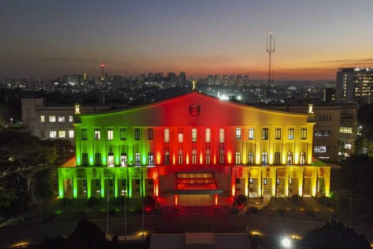 A imagem mostra um prédio com as cores verde, vermelho e amarelo