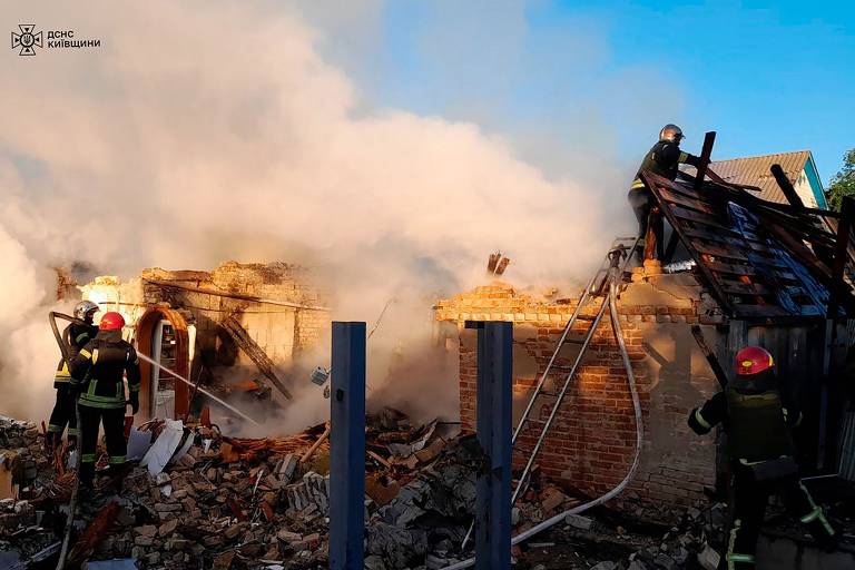 Bombeiros trabalham contra incêndio após ataque com mísseis russos na região de Kiev