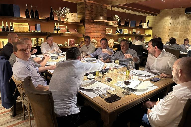 Homens sentados ao redor de uma mesa de restaurante, jantando