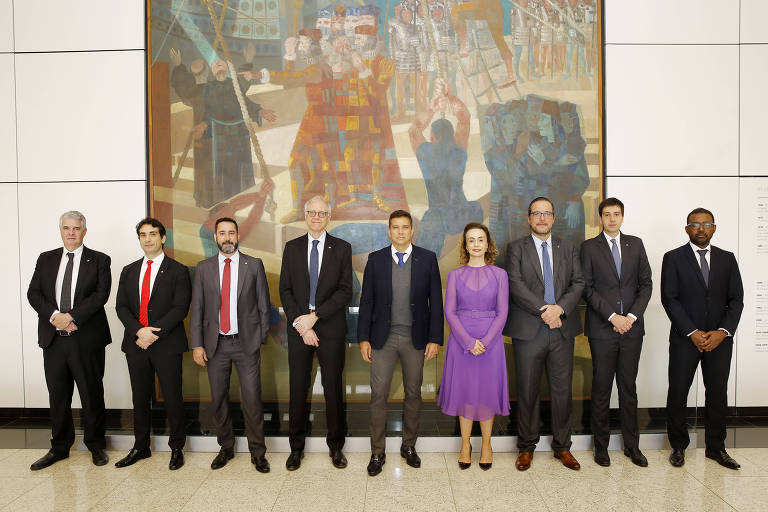 O presidente do Banco Central e os diretores da instituição em pé na sala em que está o quadro Descobrimento do Brasil, de Candido Portinari