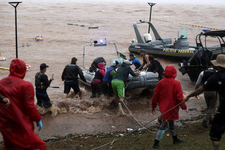 Voluntários deixam os barcos no lago Guaíba após a paralisação do resgate das vítimas da enchente, devido à volta da chuva e da ventania