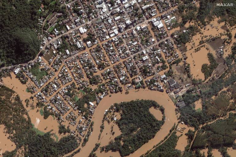 foto aérea mostra cidade alagada com água enlamaçada 