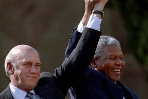 ORG XMIT: 134601_0.tif O presidente da África do Sul, Nelson Mandela (dir.), e o ex-presidente F.W. de Klerk, erguem os braços após inauguração de sindicato em Johannesburgo. South Africa turned the page on its violent political past June 2 as it voted peacefully in a watershed election expected to send Nelson Mandela into retirement with a landslide for his ruling party. Mandela and former Second Deputy President F.W. de Klerk hold their hands high as they address a huge crowd of people in front of the Union Building after the first presidential inauguration on May 10 1994. km/Photo by Juda Ngwenya REUTERS