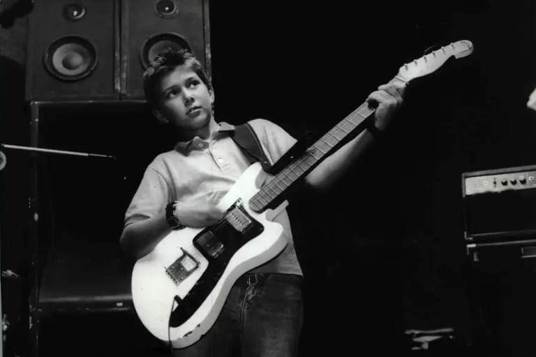 Em foto preto e branco, o músico João Suplicy, em 1985, aparece tocando uma guitarra