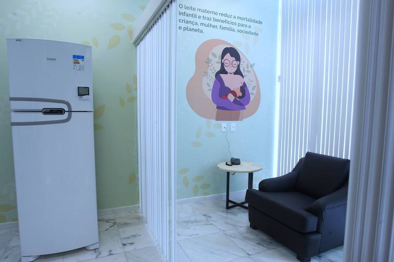 Imagem mostra sala de amamentação, com geladeira para armezar leite e e poltrona para mãe se sentar