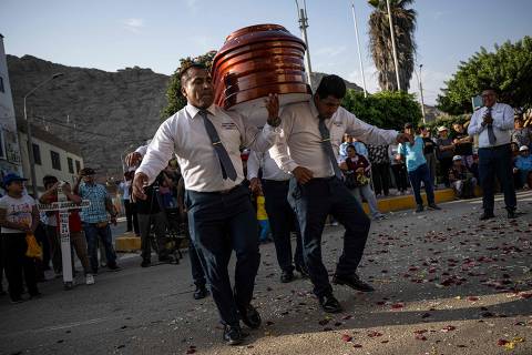 TOPSHOT - Funeral bearers dance while holding the coffin with the remains of Florentino Jamanca during his funeral in the agricultural town of Humaya in the city of Huacho, about 148 km north of Lima, Peru on May 2, 2024. Some funeral companies began offering this service eight years ago, taking advantage of the fact that in several rural parts of Peru, the farewell to the dead is usually more festive than solemn, explains Alex Canales, director of the company Cargadores Fúnebres de Huacho, one of the pioneers of the business. (Photo by Ernesto BENAVIDES / AFP)