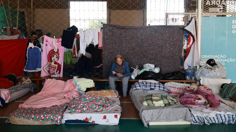 Pessoas que foram evacuadas de áreas alagadas descansam em um abrigo em uma universidade em Canoas