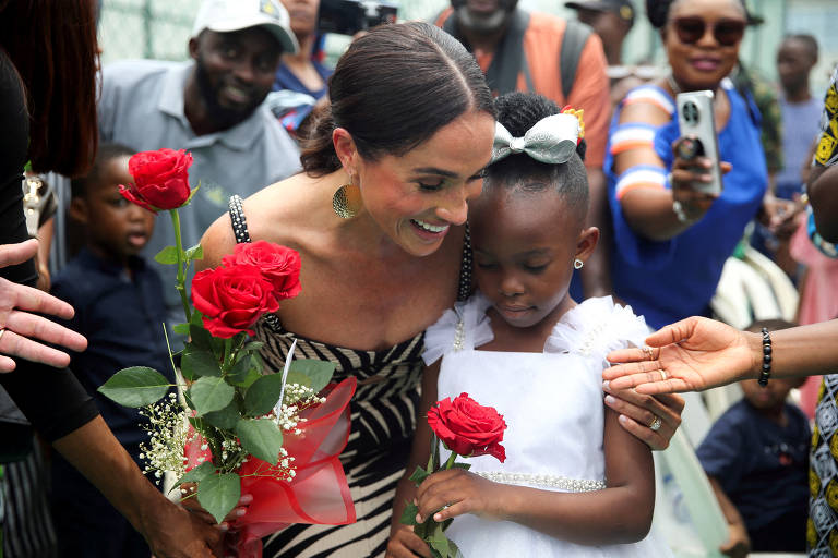 Duquesa abraça menina negra com flores vermelhas nas mãos