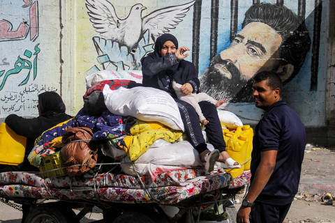 A displaced Palestinian woman, who fled Jabalia after the Israeli military called on residents to evacuate, sits atop her belongings as she travels in an animal-drawn cart, amid the ongoing conflict between Israel and Hamas, in Gaza City, May 12, 2024. REUTERS/Mahmoud Issa     TPX IMAGES OF THE DAY ORG XMIT: LIVE