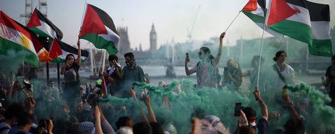 TOPSHOT - Protesters wave Palestinian flags and brandish a smoke flare during a Pro-Palestinian demonstration on Waterloo Bridge, in London, on May 11, 2024, organised by the association Youth Demand and calling for a two-way arms embargo on Israel. Israeli strikes on May 11, 2024 hit parts of Gaza including Rafah where Israel expanded an evacuation order and the UN warned of an 