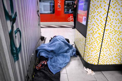 A man sleeps on a platform at a subway station in Frankfurt am Main, western Germany, on March 15, 2024. (Photo by Kirill KUDRYAVTSEV / AFP)