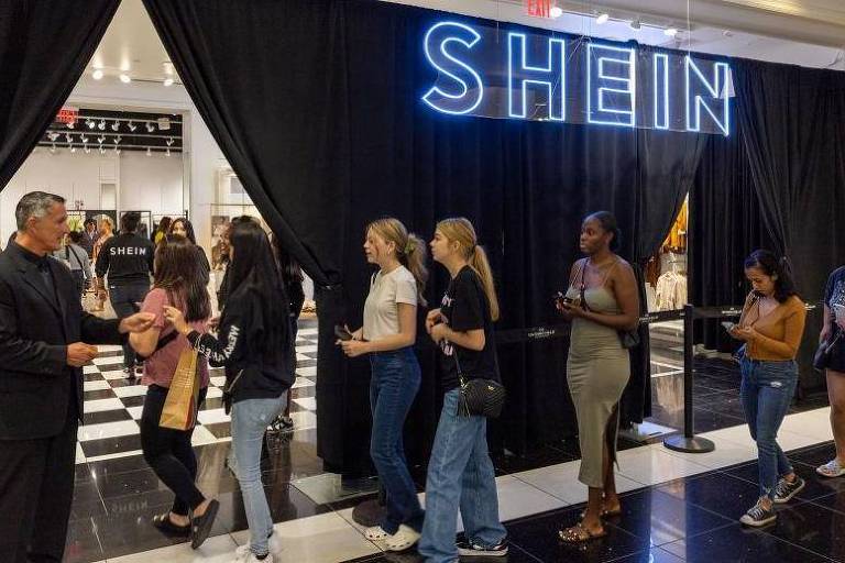 Pessoas entrando em uma loja da Shein. O Código de Conduta da Shein para seus fornecedores afirma que os trabalhadores não devem trabalhar mais de 60 horas por semana, incluindo horas extras.
