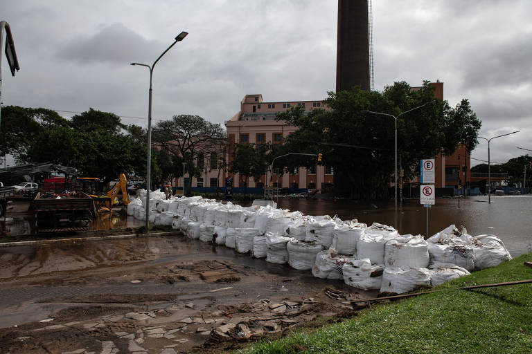 Sacos de areia reforçam a barragem montada na avenida Presidente João Goulart, em frente ao gasômetro de Porto Alegre, para evitar o avanço das águas do lago Guaíba