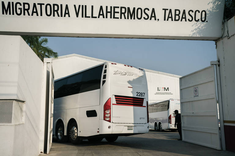 Ônibus em estacionamento onde placa lê "Migratória Villahermosa, Tabasco"