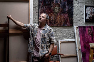 The artist Jonathan Yeo in his West London studio, with the back of the canvas with the as yet unveiled portrait of King Charles III on the left, April 9, 2024. (Mary Turner/The New York Times)