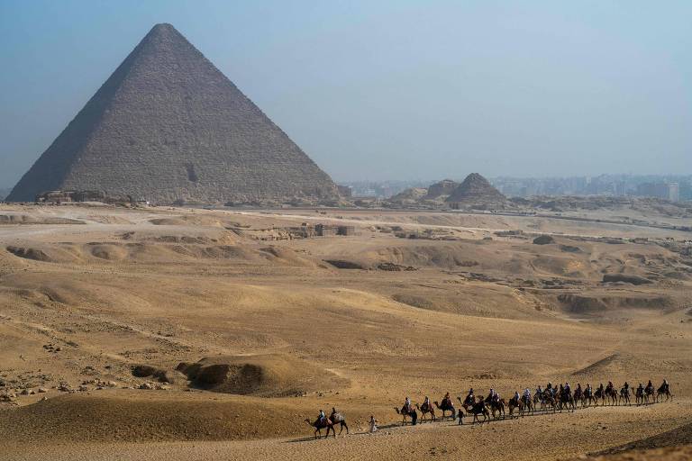 Turistas próximos à Grande Pirâmide de Guizé