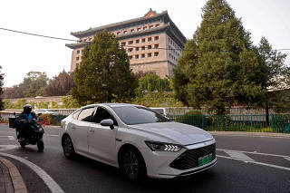 FILE PHOTO: BYD's electric vehicle (EV) Qin moves on a street in Beijing