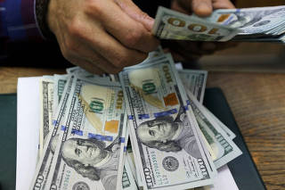 FILE PHOTO: An employee counts U.S dollar bills at a money exchange office in central Cairo