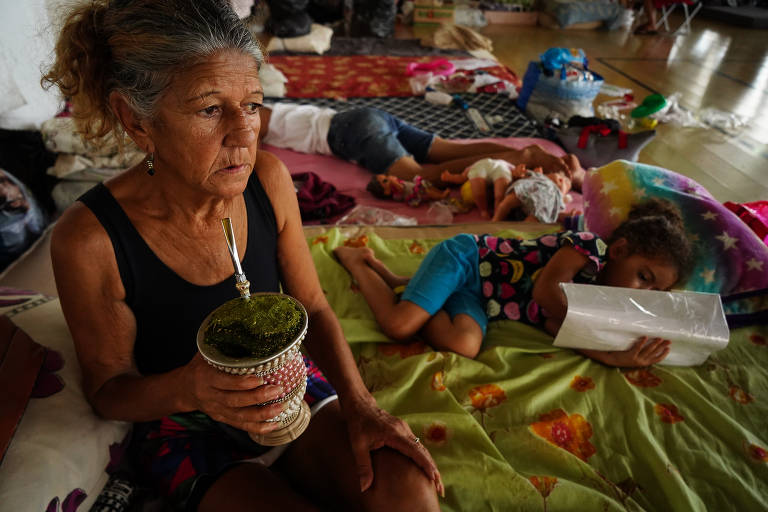 Maria Helena Oliveira toma chimarrão com os netos no abrigo montado no campus da Universidade Luterana do Brasil, a Ulbra, em Canoas