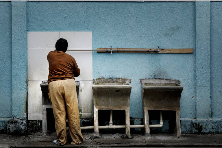 Paciente da ala feminina da instituição enche caneca com água. Diretor afirma que a água é da reserva ecológica e é tratada