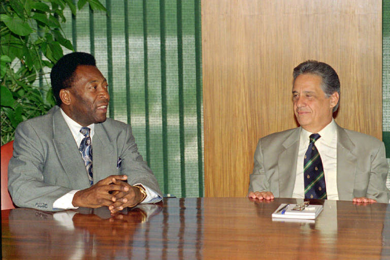 Presidente FHC e ministro Pelé vestem terno cinza em encontro no Palácio do Planalto.