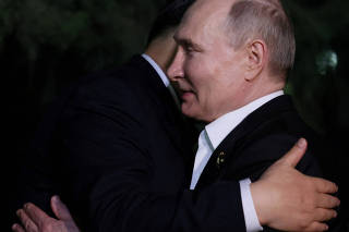 FILE PHOTO: Russian President Vladimir Putin and Chinese President Xi Jinping hug farewell at the end of talks in Beijing