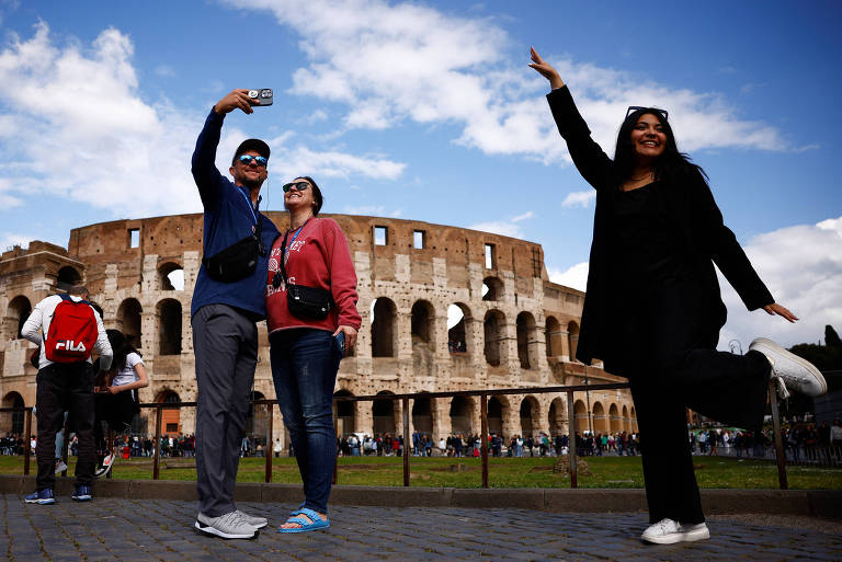 Turistas posam em frente ao Coliseu, em Roma, em abril de 2024