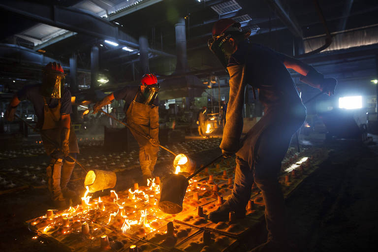 Operários especializados entornam ferro derretido em altíssima temperatura em moldes em fábrica de Barueri (SP)