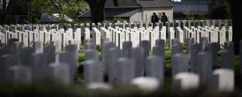 TOPSHOT - Visitors walk past the graves at the British War Cemetery of Bayeux, northwestern France, on April 9, 2024. June 6th, 2024 will mark the 80th anniversary of the Allied D-Day landings on Normandy beaches, which many considered to be the beginning of the end of World War II in Europe. (Photo by Lou BENOIST / AFP)