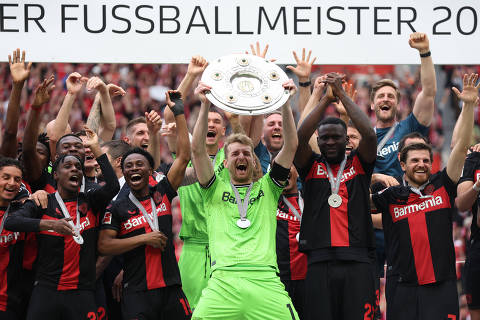 Soccer Football - Bundesliga - Bayer Leverkusen v FC Augsburg - BayArena, Leverkusen, Germany - May 18, 2024 Bayer Leverkusen's Lukas Hradecky lifts the trophy as they celebrate after winning the Bundesliga and going unbeaten REUTERS/Thilo Schmuelgen DFL REGULATIONS PROHIBIT ANY USE OF PHOTOGRAPHS AS IMAGE SEQUENCES AND/OR QUASI-VIDEO.