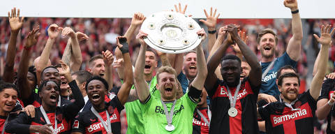 Soccer Football - Bundesliga - Bayer Leverkusen v FC Augsburg - BayArena, Leverkusen, Germany - May 18, 2024 Bayer Leverkusen's Lukas Hradecky lifts the trophy as they celebrate after winning the Bundesliga and going unbeaten REUTERS/Thilo Schmuelgen DFL REGULATIONS PROHIBIT ANY USE OF PHOTOGRAPHS AS IMAGE SEQUENCES AND/OR QUASI-VIDEO.