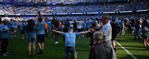 Manchester City fans invade the pitch to celebrate their team's win, after the English Premier League football match between Manchester City and West Ham United at the Etihad Stadium in Manchester, north west England, on May 19, 2024. Manchester City created English football history on Sunday, beating West Ham 3-1 to win an unprecedented fourth straight Premier League title. (Photo by Oli SCARFF / AFP) / RESTRICTED TO EDITORIAL USE. No use with unauthorized audio, video, data, fixture lists, club/league logos or 'live' services. Online in-match use limited to 120 images. An additional 40 images may be used in extra time. No video emulation. Social media in-match use limited to 120 images. An additional 40 images may be used in extra time. No use in betting publications, games or single club/league/player publications. /