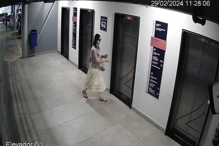 mulher com cabelos pretos e vestido branco entra em elevador
