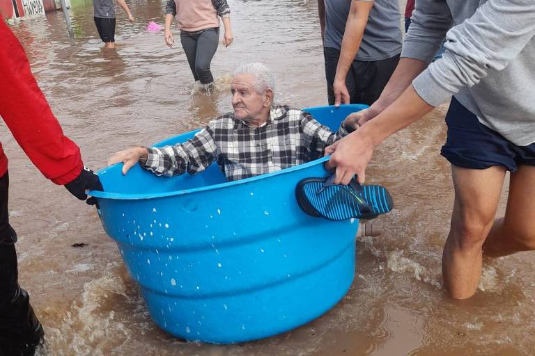 O aposentado Claro Neves, de 82 anos, em seu resgate dentro de uma caixa d'água na cidade de Canoas (RS); ele tem Alzheimer diagnosticado há 3 anos e está na casa da filha, porque a casa dele ficou alagada até o telhado