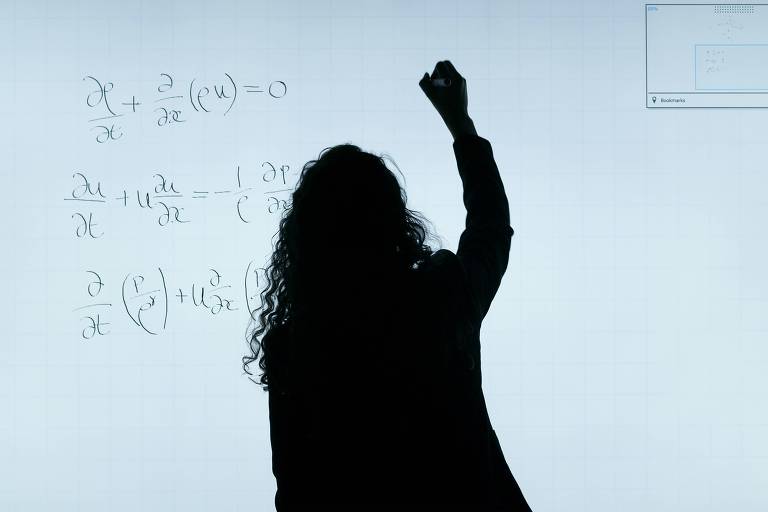 Sombra de uma mulher com cabelos cacheados escrevendo equações em uma lousa branca
