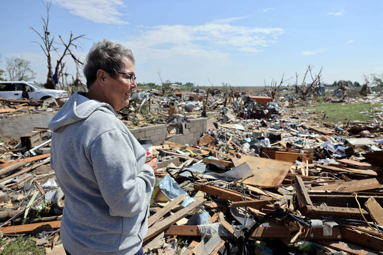 Mulher observa destruição provocada por passagem de tornado em Greenfield, no estado americano de Iowa