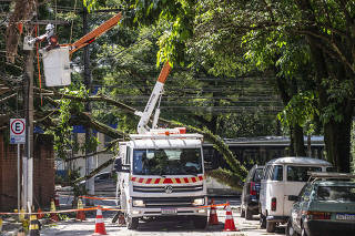 Chuvas em Sao Paulo, rescaldo: Tecnicos da Enel desligam energia em fiacao na rua Prestes Joao (no Ibirapuera) devido a queda de arvores