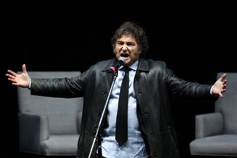 Argentina's President Javier Milei gestures on stage as he presents his new book 