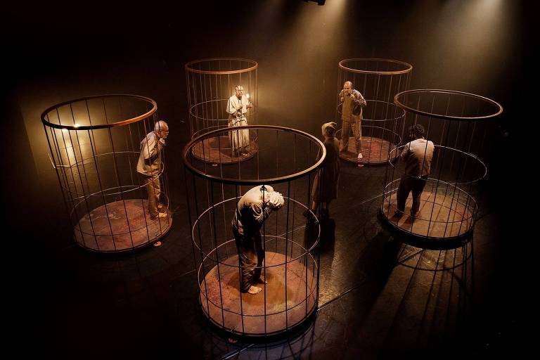 Seis atores estão confinados em gaiolas circulares individuais