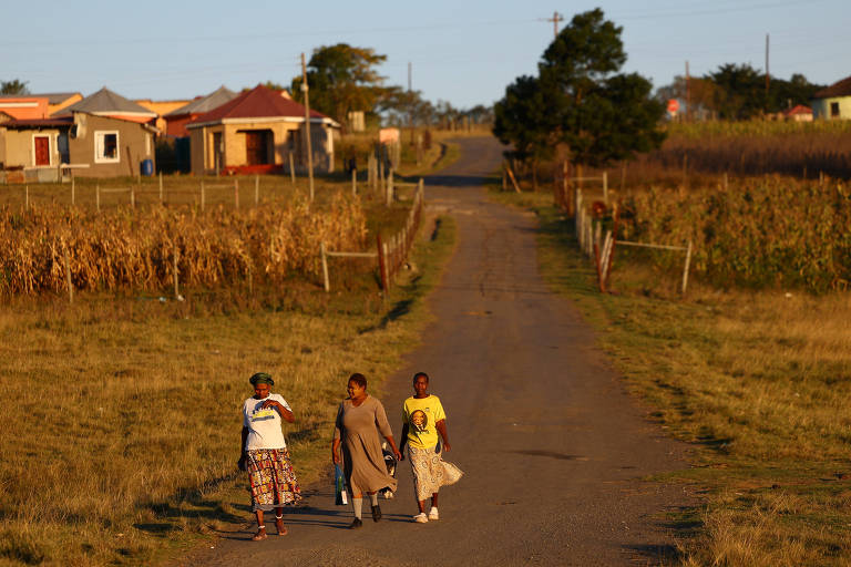 Trabalhadores andam em frente a planta de energia na África do Sul