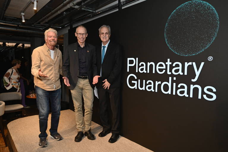 Três homens lado a lado com painel com o escrito Planetary Guardians