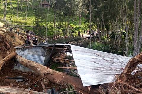 This picture shows a demolished house at the site of a landslide at Yambali Village in the region of Maip Mulitaka, in Papua New Guinea's Enga Province on May 25, 2024. Rescue teams began arriving at the site of a massive landslide in Papua New Guinea's remote highlands on May 25, helping villagers search for the scores of people feared dead under the towering mounds of rubble and mud. (Photo by AFP) ORG XMIT: DBG200