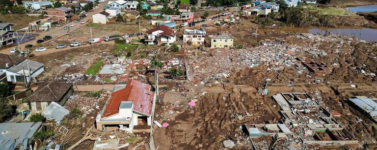 Foto aérea mostra casas e ruas destruídas pela enchente e cobertas de lama