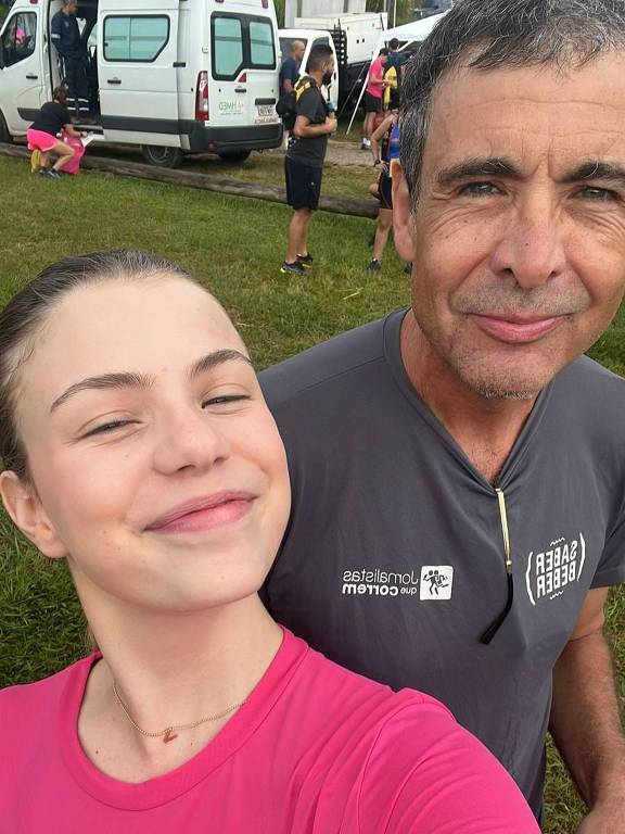 Paulo Vieira e sua filha. Os dois vestem roupas esportivas para corrida e sorriem para a foto. É uma selfie.