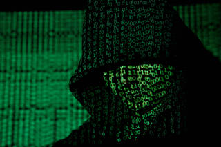FILE PHOTO: Projection of cyber code on hooded man is pictured in this illustration picture